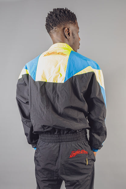 Model wearing Jayghaer Pierre colorblock black, blue, and white luxury tracksuit from the back